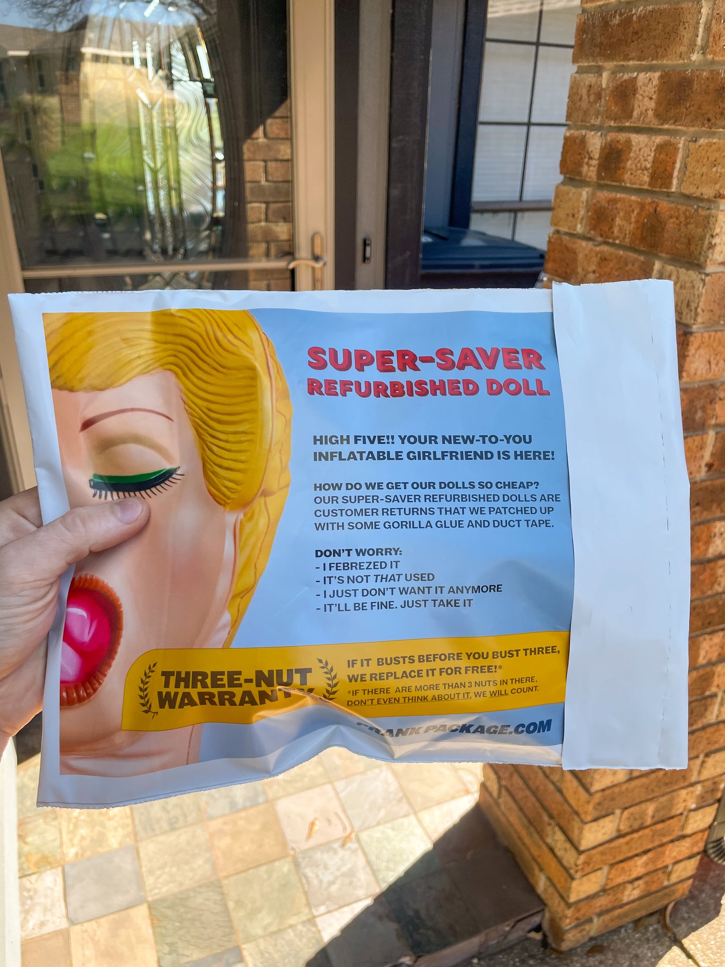 POV of a delivery man reading the back of our Budget Blow-Up Doll embarrassing prank package before delivering it to someone's doorstep. Hilarious 3-nut warranty, "If it busts before you bust 3, we replace it for free!"