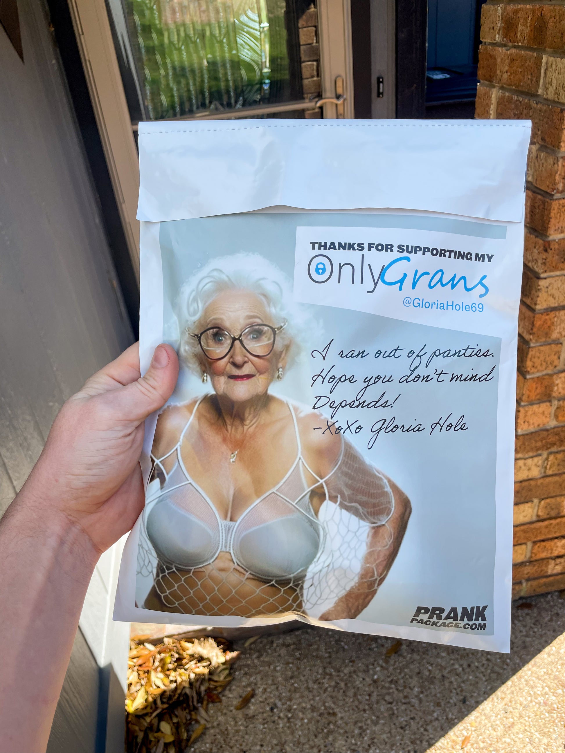 A POV shot showing the bac of the Used Granny Panties prank mailer. "Thanks for supporting my OnlyGrans" is in huge text across the back of the package.